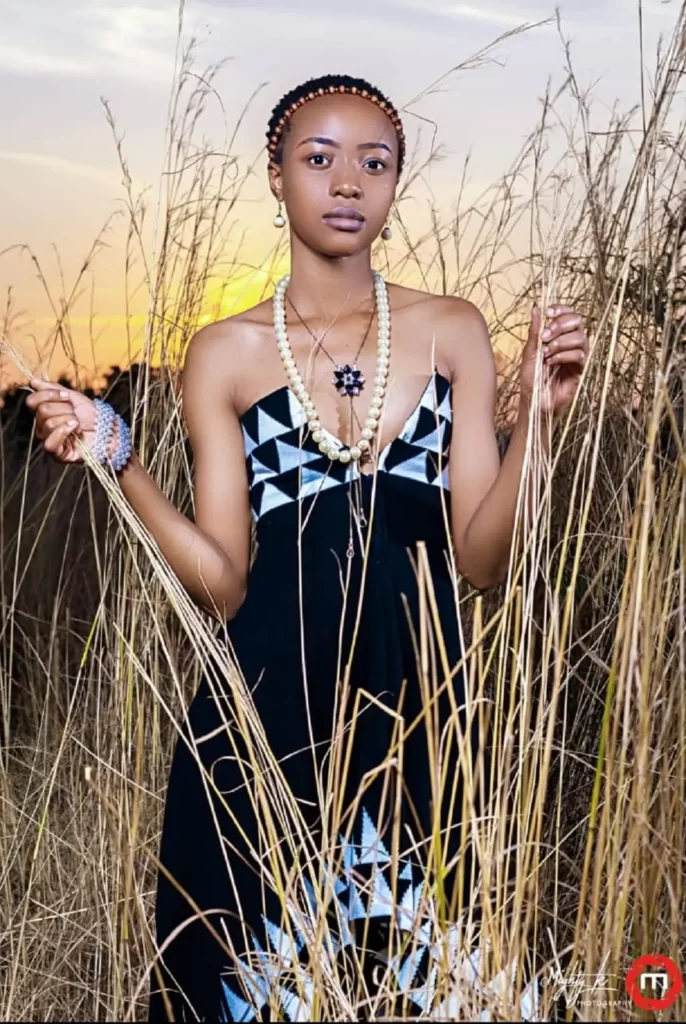 African model Nokutenda Shekinah in cultural wear holding dry grass