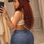 Badgyal Nera Style Guide: Luxury Curves Fashion, Premium Denim Trends & Modern Glam Beauty Secrets Badgyal Nera wearing high-waisted premium denim jeans, ivory crop top and leather cowboy hat with long red curls in boutique mirror selfie