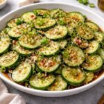Best Viral Cucumber Salad Recipe – Healthy & High Protein Viral cucumber salad with thin cucumber slices, sesame seeds, green onions, garlic, and soy-vinegar dressing in a white bowl
