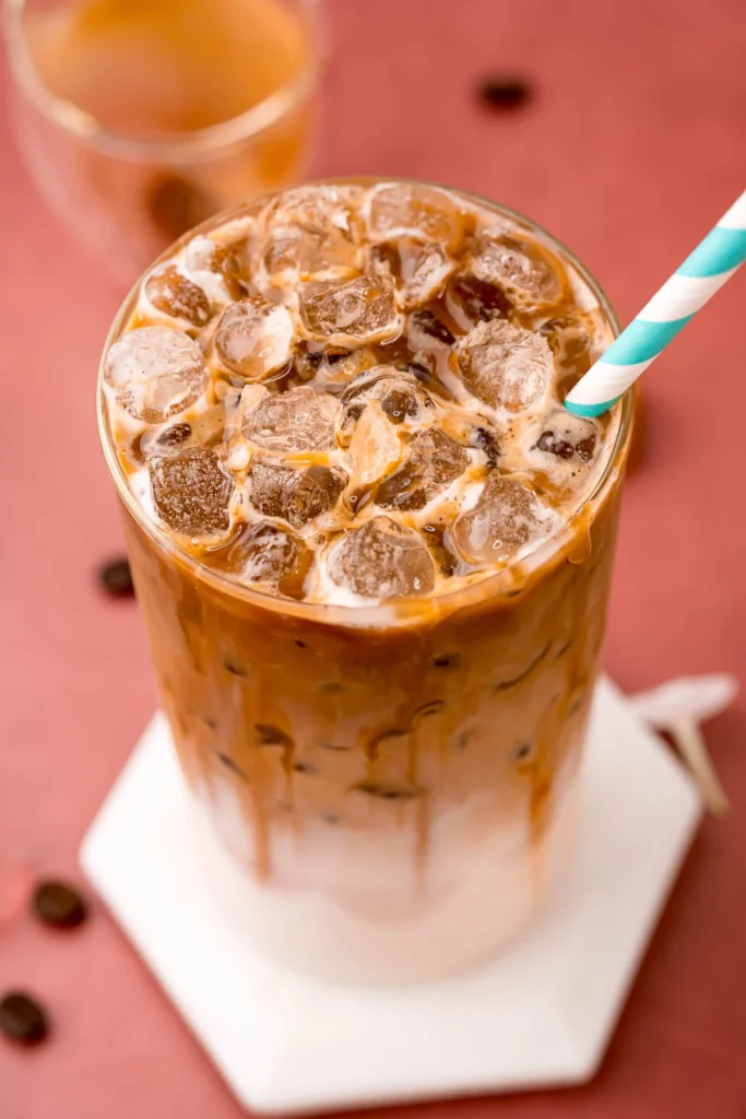 Top view of iced caramel macchiato with caramel drizzle and ice cubes