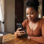 How to Get a Loan on Zamcash Online in Zambia (Step-by-Step Guide) Young Zambian woman checking her Zamcash loan approval on a smartphone
