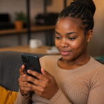 ZamCash: Get a Loan Online in Zambia Today in 5 Minutes Zambian woman using smartphone to apply for ZamCash loan online in Zambia today in 5 minutes