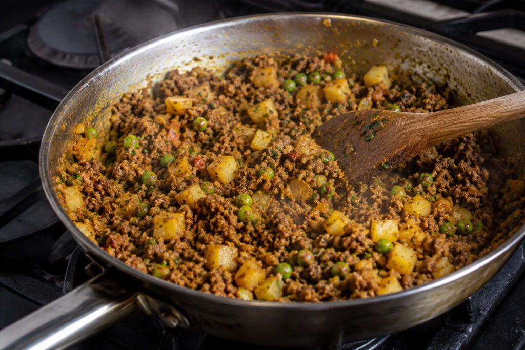 Spiced minced beef and potato filling for Zambian samosas cooking in a pan