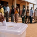 What Are the 3 Main Types of Electoral Systems in Zambia? Zambian voter casting a ballot into a transparent ballot box during a general election, with a queue of voters waiting in line